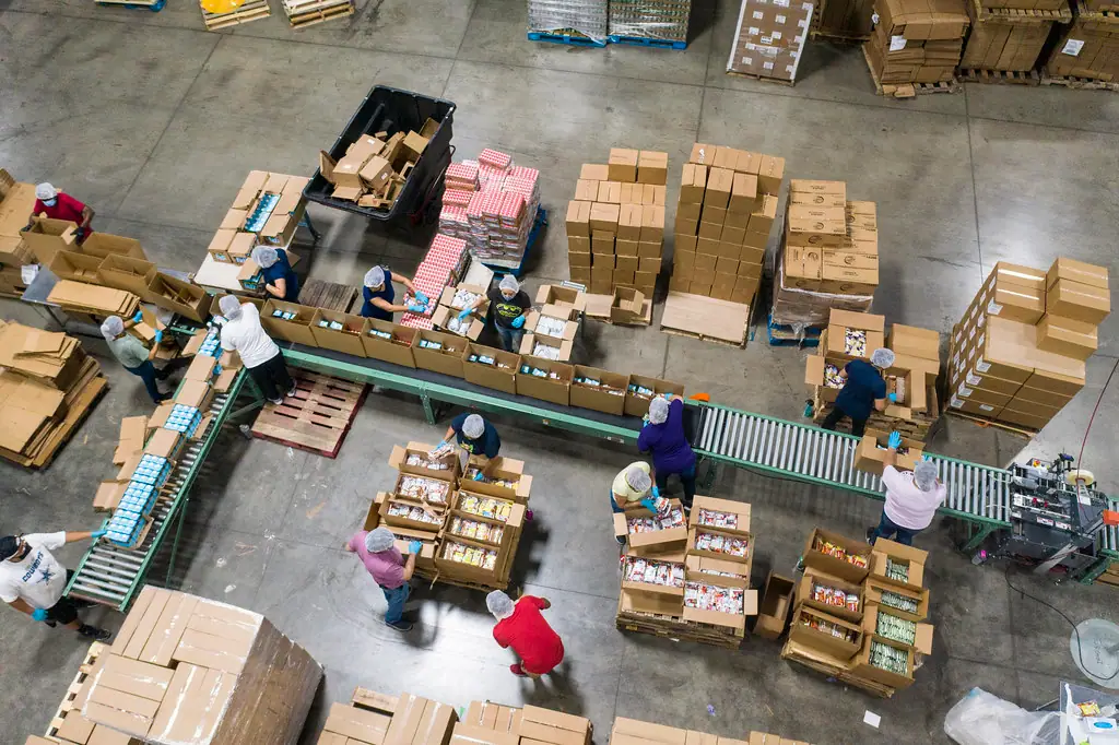 Overhead view of a packing line with conveyors and stacked cartons